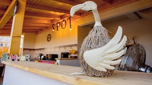 A rustic interior with a wooden ceiling, a decorative swan sculpture, and a counter with the word "SUMMER" visible. - Spot Vama Veche (Limanu)