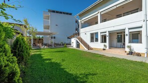 A modern two-story house with a spacious backyard, a staircase leading to the upper floor, and a clear blue sky. - Spot Vama Veche (Limanu)