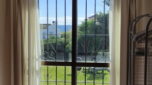 A room with a large sliding glass door leading to a balcony, a patterned rug on the floor, and a metal rack on the right. - La Gaspara's loft (Estepona)