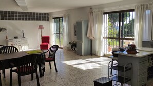 A spacious kitchen with a dining area, large windows, and a clock on the wall. - La Gaspara's loft (Estepona)