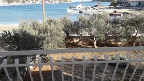 A coastal view with a marina, olive trees, and a white fence. - Apartment in Vinišće with Seaview, Terrace, Air condition, WIFI (4752-1) (Vinišce)
