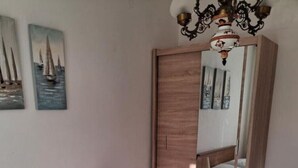 A bedroom with a large bed, a nightstand, a mirror, and artwork on the wall. - Apartment in Vinišće with Seaview, Terrace, Air condition, WIFI (4752-1) (Vinišce)