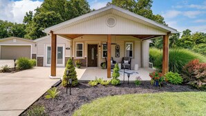 A single-story house with a covered porch, a garage, and a well-maintained garden.