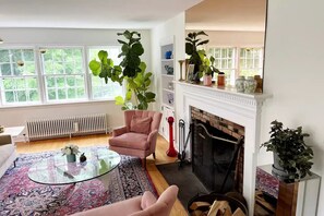 Cozy living room with a fireplace, comfortable seating area, and large windows.