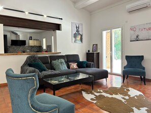 A modern living room with a sofa, armchairs, a glass coffee table, and a cowhide rug. - Propriété de Campagne, Située Entre le Circuit Paul Ricard et Bandol (Le Beausset)