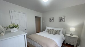 Un dormitorio con cama, mesita de noche y una pequeña alfombra.