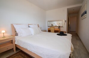 A neatly made bed with white linens, a bedside table with a lamp, and a mirror above a wooden dresser. - Ref: 298 Spacious seafront 3 bed/2 bath apartment with amazing views (Fuengirola)