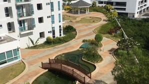A residential complex with modern architecture, a central courtyard with a bridge, and a small pond. - The Mactan Newtown (Lapu-Lapu)