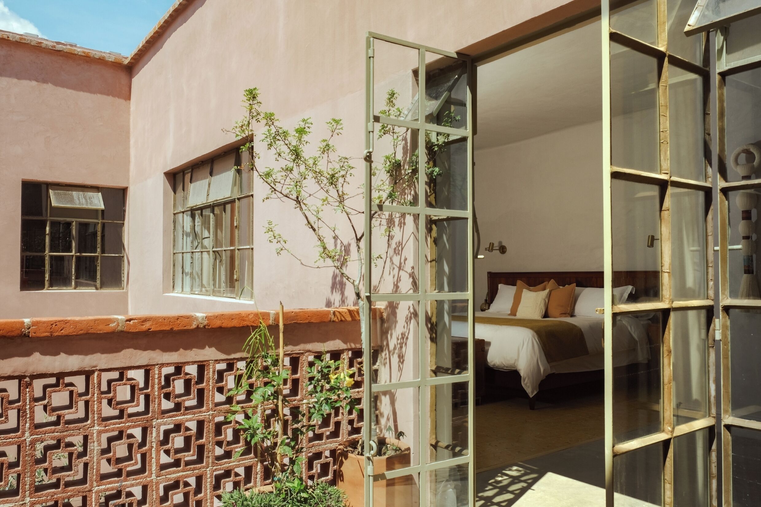 A hotel room with a bed, a window, and a view of the outside.