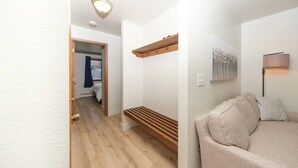 A hallway with a wooden bench, a sofa, and a lamp. - Groundfloor Modern Industrial 2BD Apartment (Anchorage)