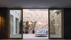 Un interior moderno con una pared de piedra, un sofá y plantas en macetas.
