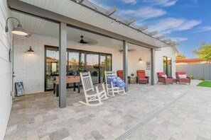 Un patio couvert avec des sièges, une table et une table de baby-foot.