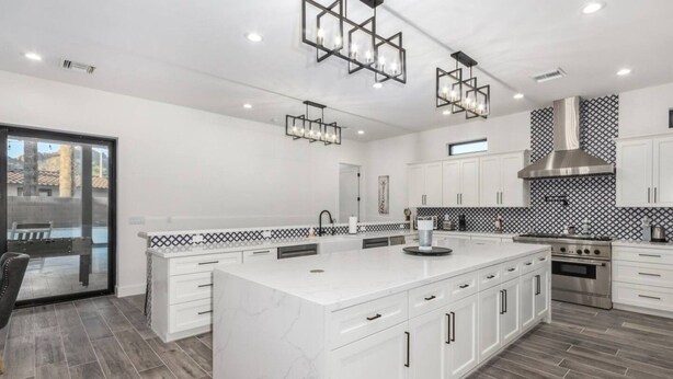 A modern kitchen with white cabinetry, a large island, and a stainless steel range hood. - Arcadia/Scottsdale 4bedroom/4.5bath Camelback Mountain New Build-Prime Location (Phoenix)