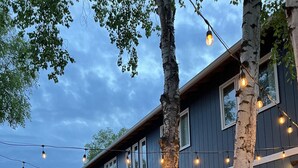 A two-story house with a covered porch and a car parked in the driveway. - Delightful Sleek Modern 2 Bed 1 Bath apt (Anchorage)