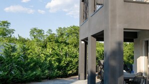 A modern house with a swimming pool, outdoor furniture, and a view of trees. - Villa Lota with a heated pool, sauna & E-car charger (Sveti Ivan Dobrinjski (Krk))