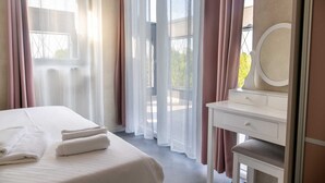 A hotel room with a bed, a vanity with a mirror, and sheer curtains. - Villa Lota with a heated pool, sauna & E-car charger (Sveti Ivan Dobrinjski (Krk))