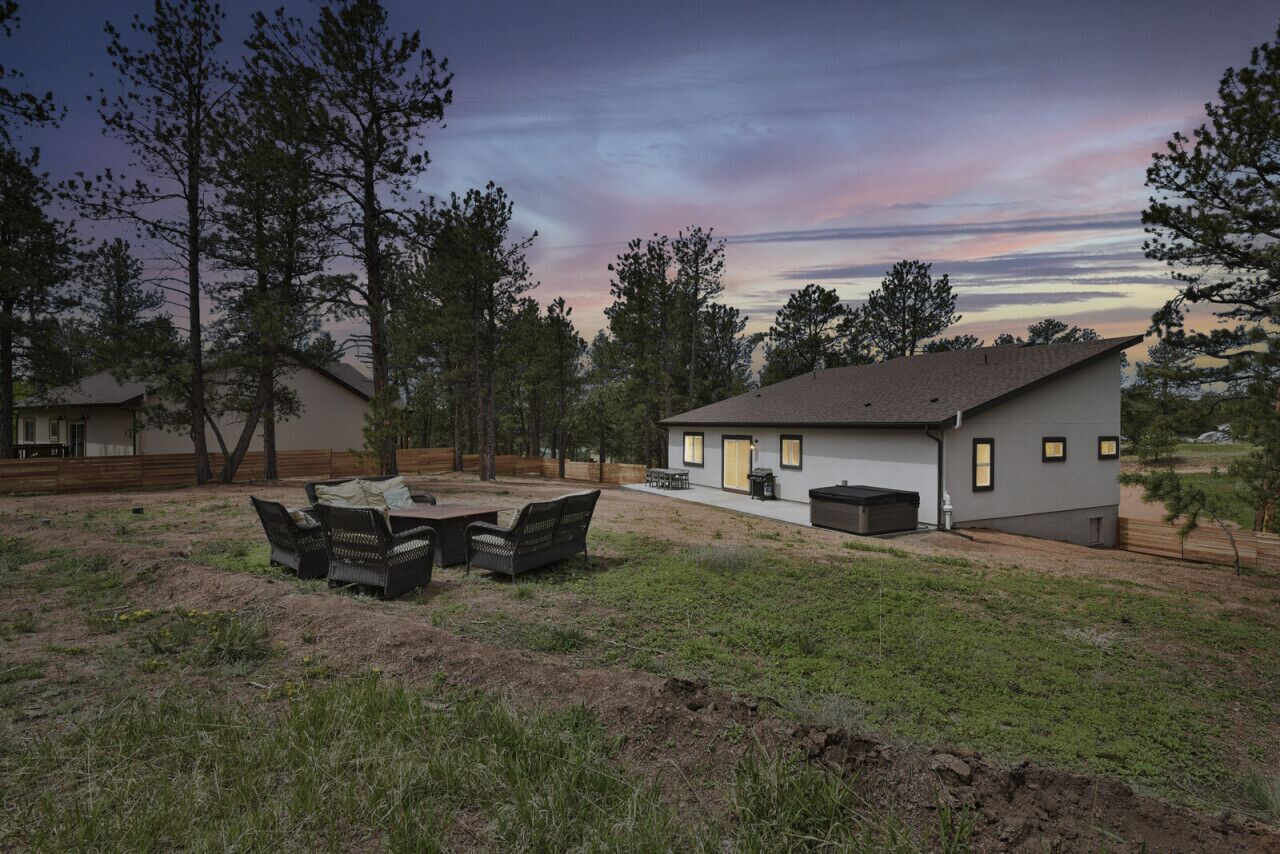 Una casa moderna con un patio, una pequeña terraza y un ventanal grande.