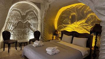 A room with a bed, two chairs, and a wall with a light projection.
