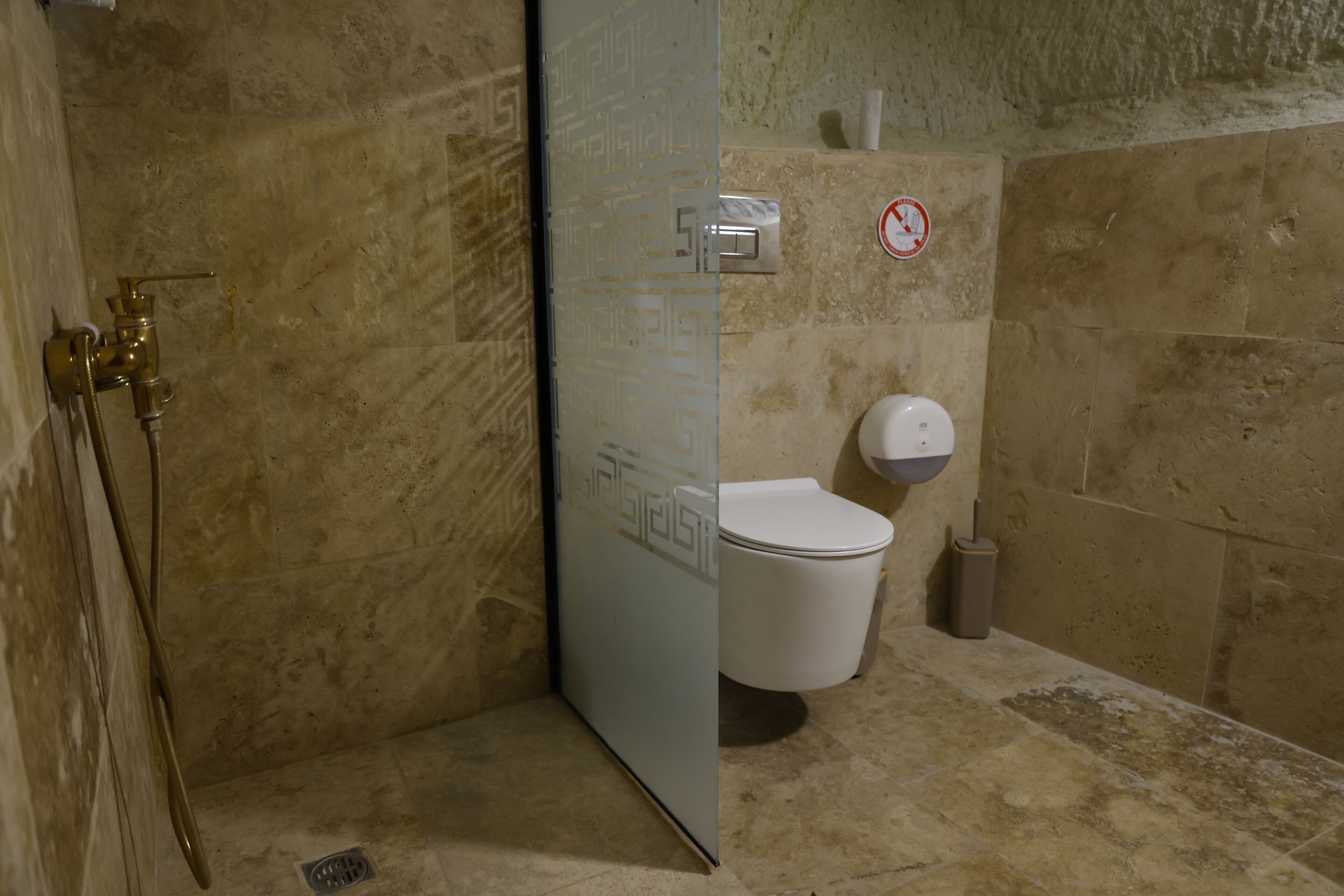 Un baño con ducha, inodoro y secamanos.