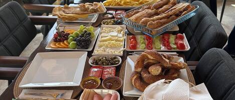 Een ontbijtbuffet met diverse gerechten en een mooi uitzicht door het raam.