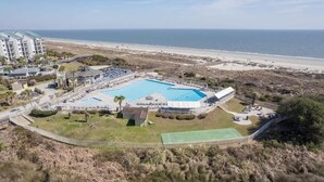 Een resort met een groot zwembad, toegang tot het strand en uitzicht op de oceaan.