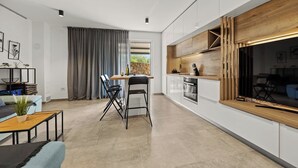A modern kitchen with white cabinets, a wooden countertop, and a built-in oven. - Couple's Vacation with Jacuzzi - Crepsa Paradise (Cres)