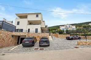 A multi-story building with a stone facade and a paved driveway. - Couple's Vacation with Jacuzzi - Crepsa Paradise (Cres)