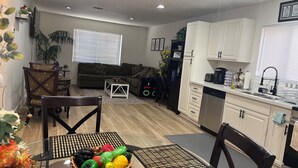 Un appartement moderne comprenant un coin repas, une cuisine et un salon.