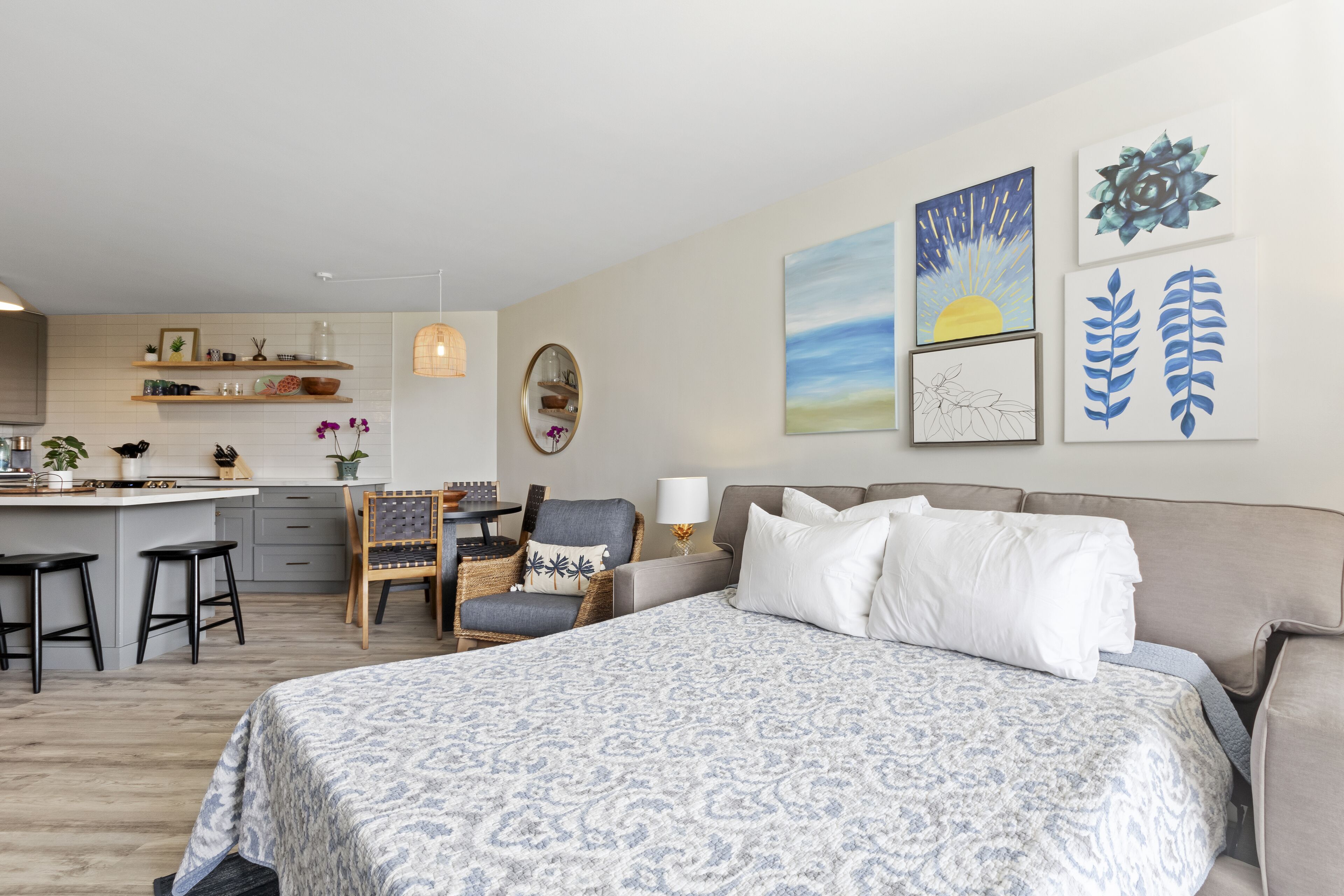 Une chambre d’hôtel moderne dotée d’un grand lit, d’un coin repas et d’œuvres d’art accrochées aux murs.