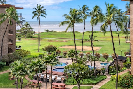 A resort with a pool, outdoor seating, and a view of the ocean.