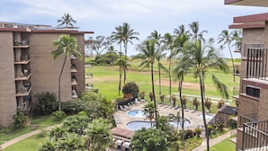 A hotel with multiple balconies, a swimming pool area, and palm trees. - Aloha Chic Penthouse Vistas (Kihei)