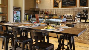 Un restaurant avec un long comptoir, de nombreuses chaises et une machine à café.