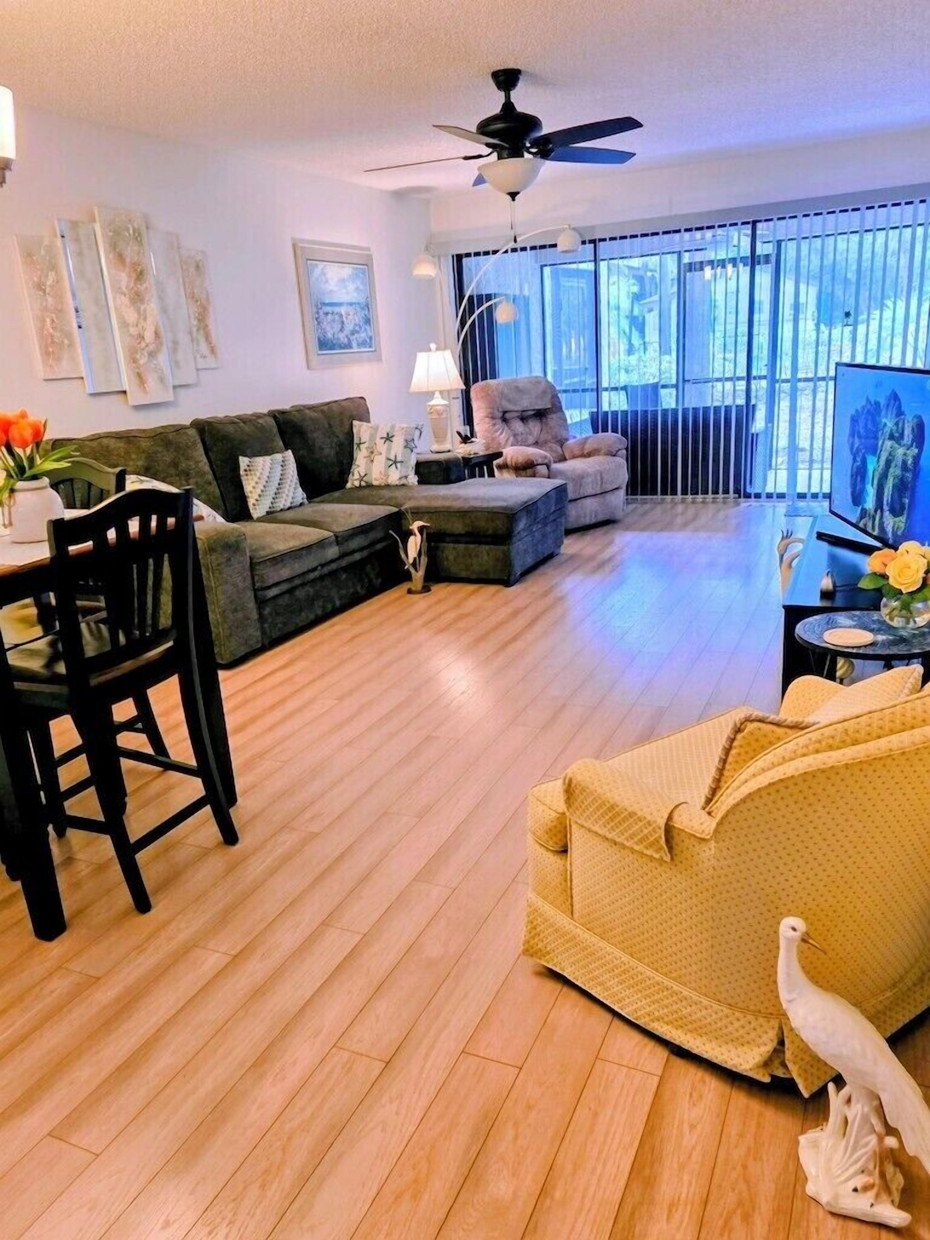 Ein Wohnzimmer mit einer Couch, einem Sessel, einem Esstisch und Stühlen.