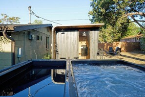 A hot tub area with a wooden deck, a sauna, and outdoor seating. - Stunning Sedona Modern Bungalow | Private Spa-Style Backyard | EV Charger (Sedona)