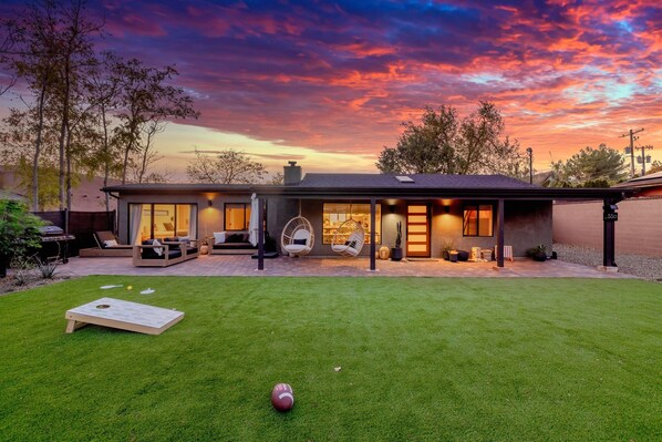 A modern house with a large patio, outdoor seating, and a well-maintained lawn. - Stunning Sedona Modern Bungalow | Private Spa-Style Backyard | EV Charger (Sedona)