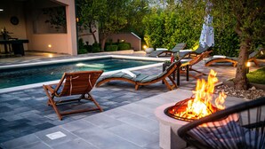 A poolside area with lounge chairs, a fire pit, and a dartboard. - Beautiful home in Polaca (Polaca)