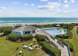 A coastal property with a large swimming pool, a gazebo, and a beach view. - First Floor Pebble Beach
3BR/2BA Oceanview Condo 
Steps from the Beach
 (Emerald Isle)