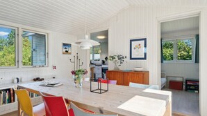 A modern kitchen with a wooden table, red and yellow chairs, and a view of the outdoors. - Amazing home in Jægerspris with kitchen (Jægerspris)