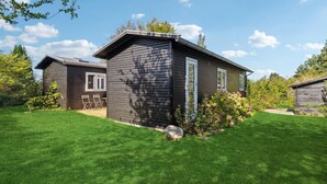 A two-story wooden cabin with a small porch and a well-maintained lawn. - Amazing home in Jægerspris with kitchen (Jægerspris)