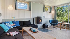 A modern living room with a sofa, coffee table, and a fireplace. - Amazing home in Jægerspris with kitchen (Jægerspris)