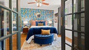 A bedroom with a large bed, a ceiling fan, and a window with a view. - 1 Acre Estate Across the Lake from LSU (Baton Rouge)