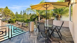 A balcony with a pool, outdoor furniture, and a view of the surrounding greenery. - Granada Hills Estate | Lap Pool, Spa & Guesthouse (Los Angeles)