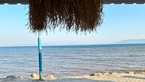 A beach view with a wooden deck and a hanging structure. - Apelles Butik Otel (Seferihisar)