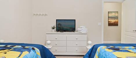 A hotel room with two beds, a TV on a dresser, and a painting on the wall.