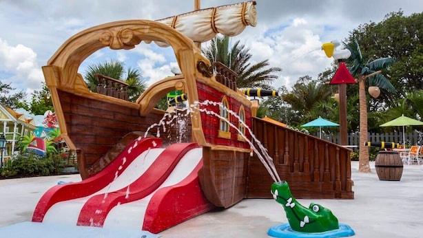 A pirate-themed water play area with a ship structure, slides, and a crocodile float. - Casa Serene 3Bd near Disney @Festival Resort 963 (Davenport)