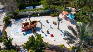 A water play area with a pirate ship, palm trees, and outdoor seating. - Charming 3Bd Close to Disney @ Festival 1026 (Davenport)