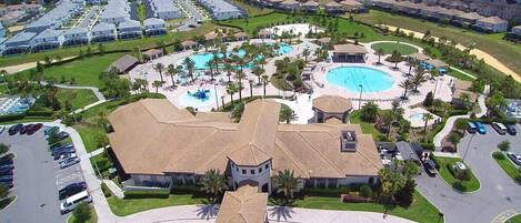 A resort with multiple swimming pools, a central building, and a parking area.