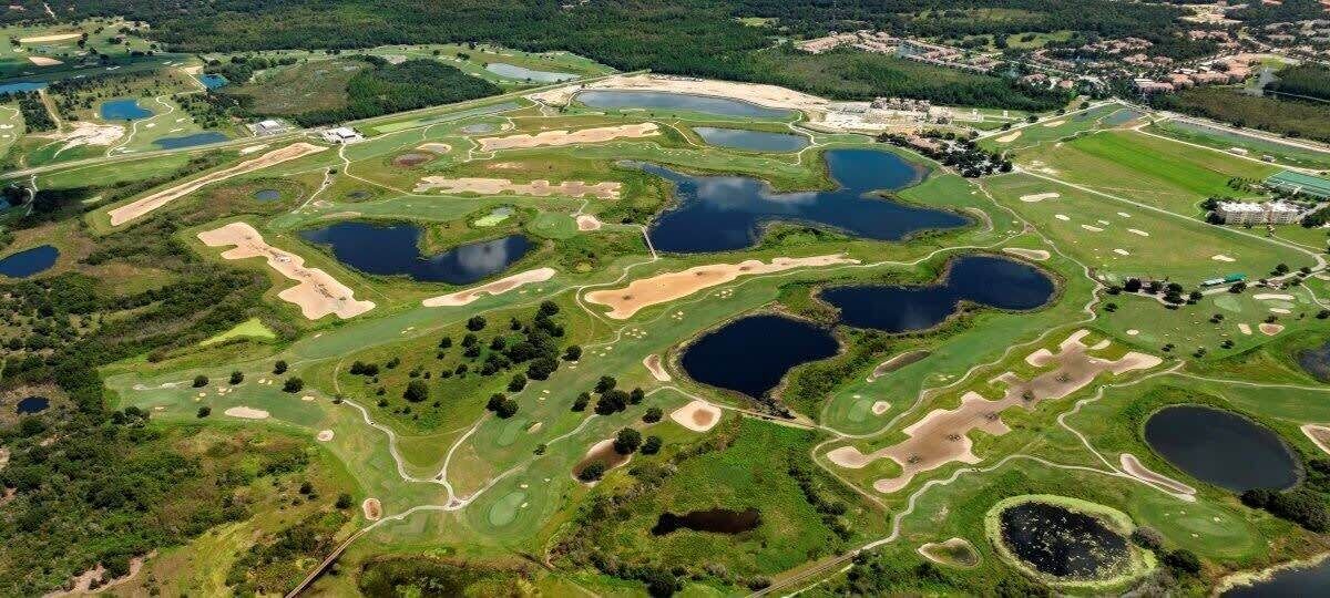 An aerial view of a golf course with multiple ponds and sand traps.