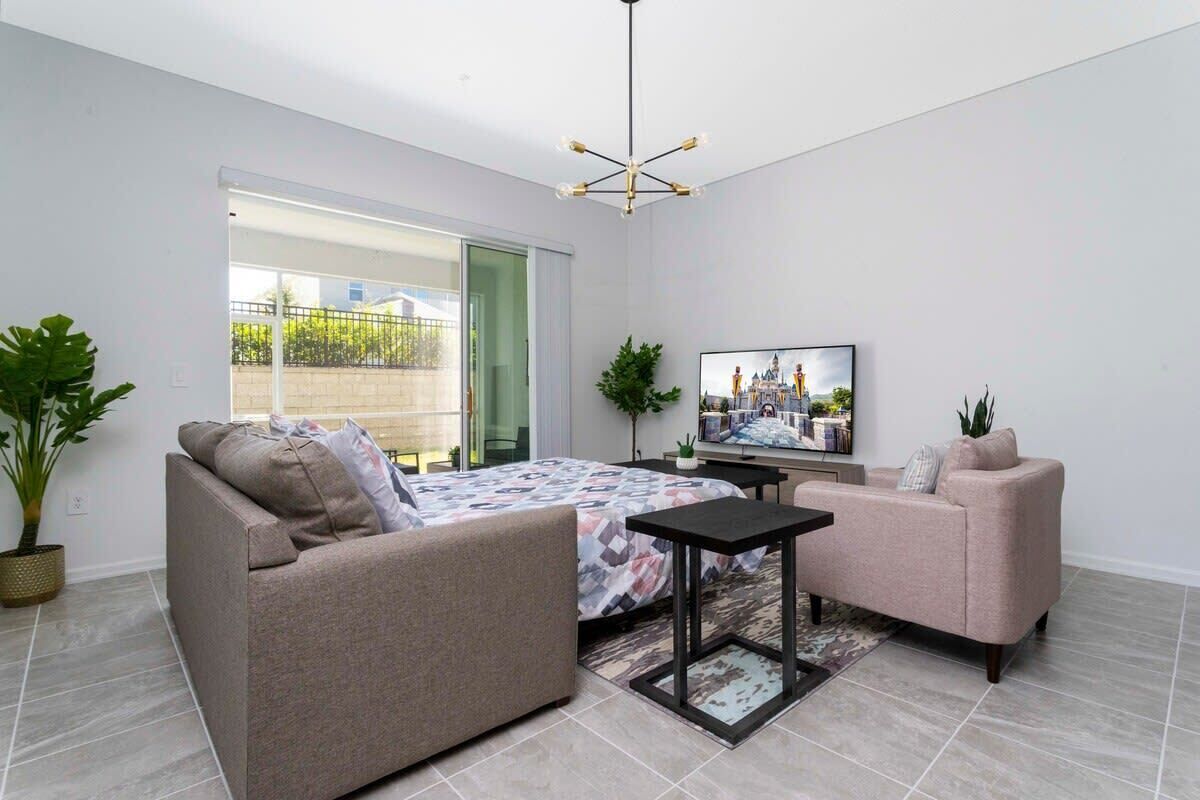 A modern living room with a sofa, a coffee table, and a TV.