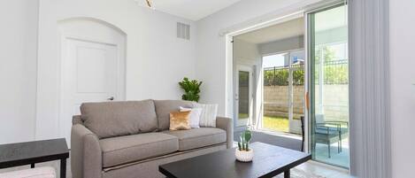 A modern living room with a sofa, a coffee table, and a plant.